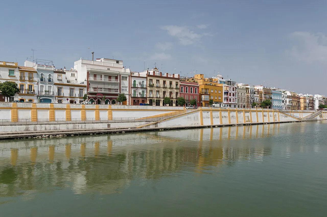 Colourful houses along the Triana riverbank reflected in the Guadalquivir, Seville