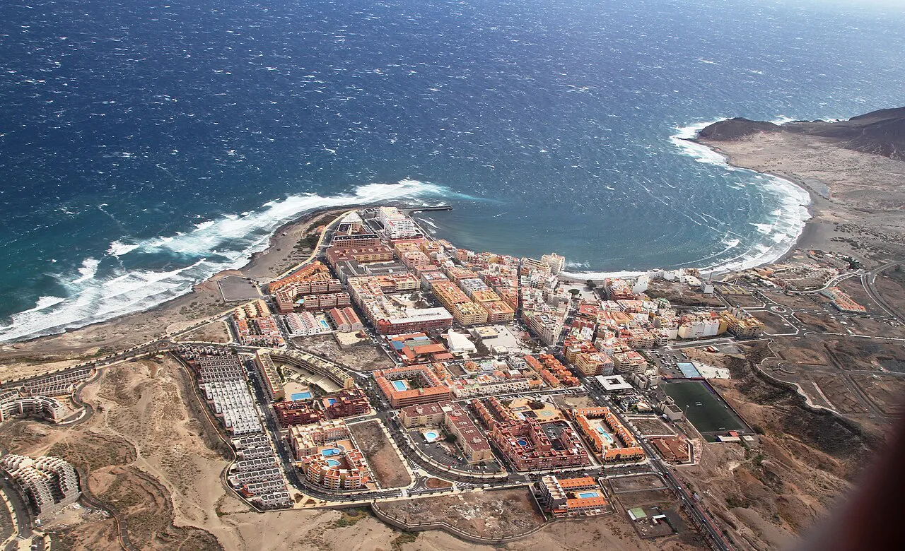 Aerial view of El Médano on Tenerife's south coast, its streets beside a curving bay and headland
