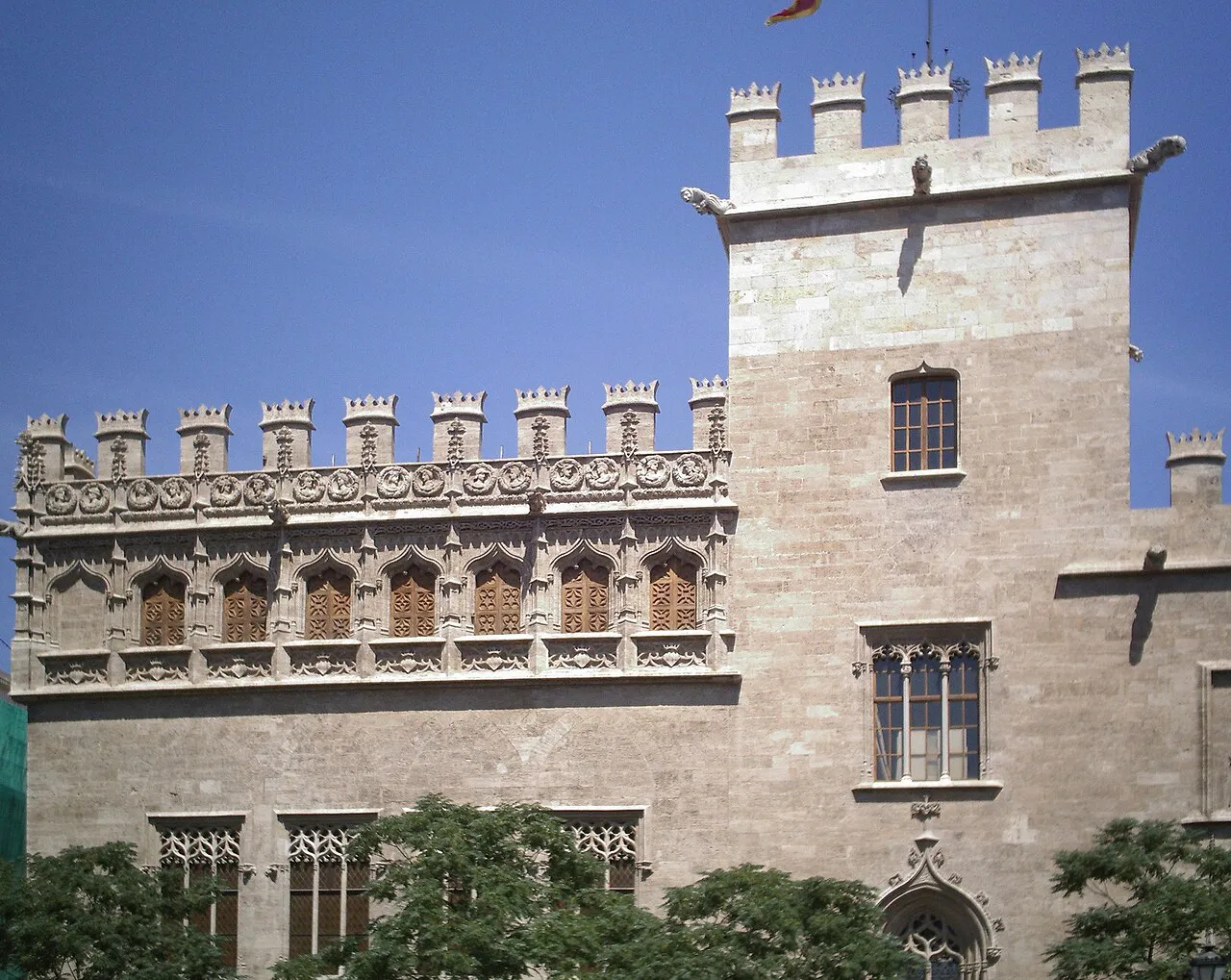 Gothic stone facade and crenellated tower of La Lonja de la Seda in Valencia's old town