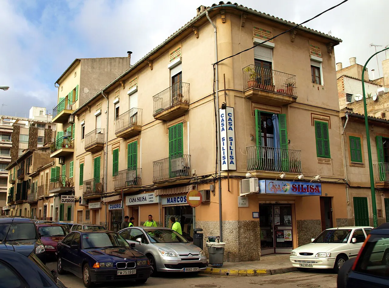 Ochre apartment buildings with green shutters on Carrer de Soler in Palma’s Santa Catalina district