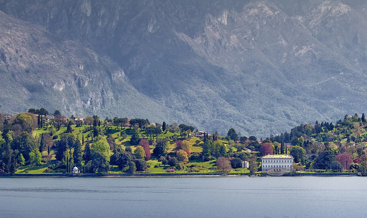 Lakeside gardens of Villa Melzi in autumn colours below mountains, Bellagio, Lake Como
