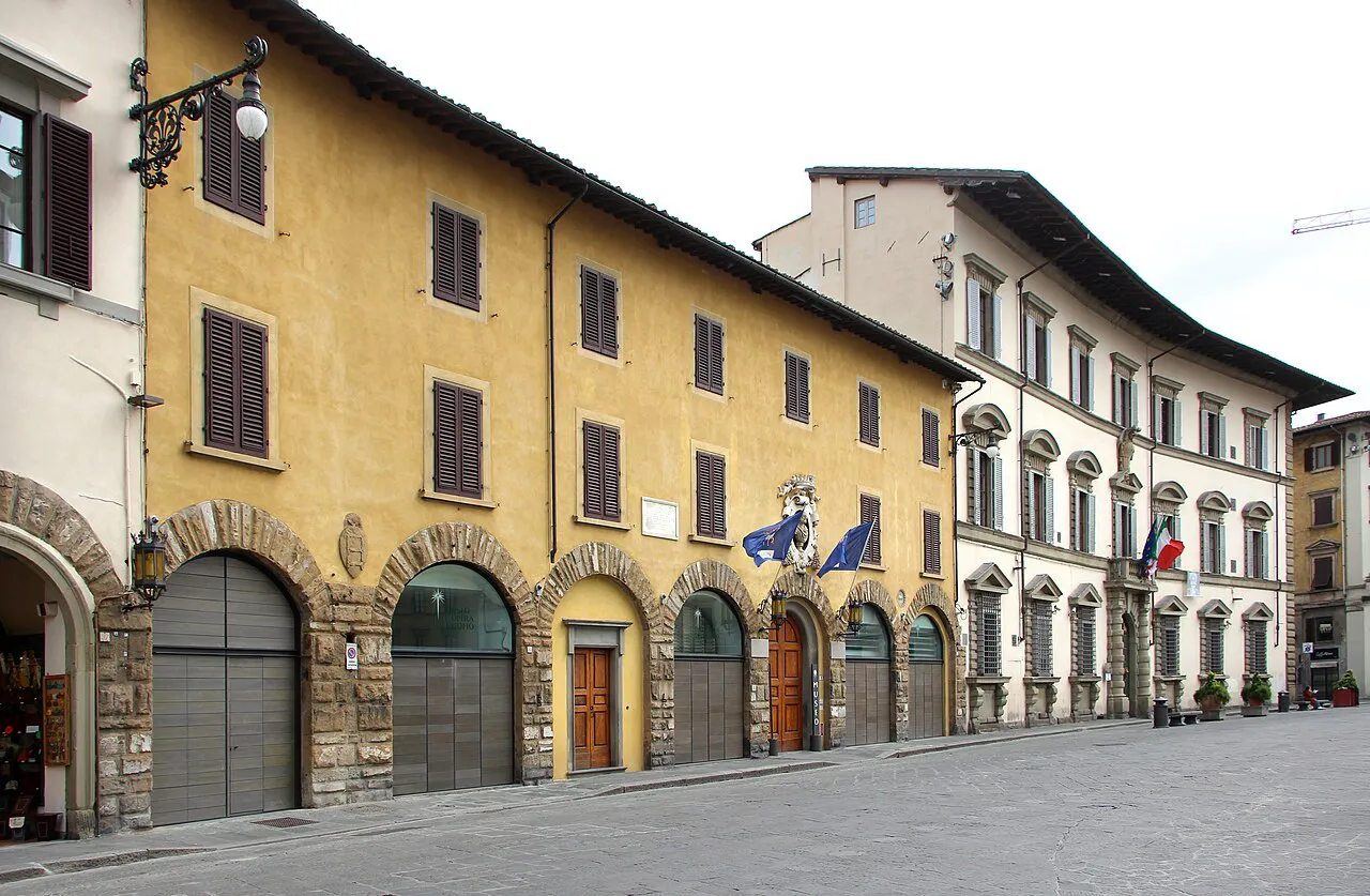 Pale stone palazzi with arched ground floors on the north side of Piazza del Duomo in Florence