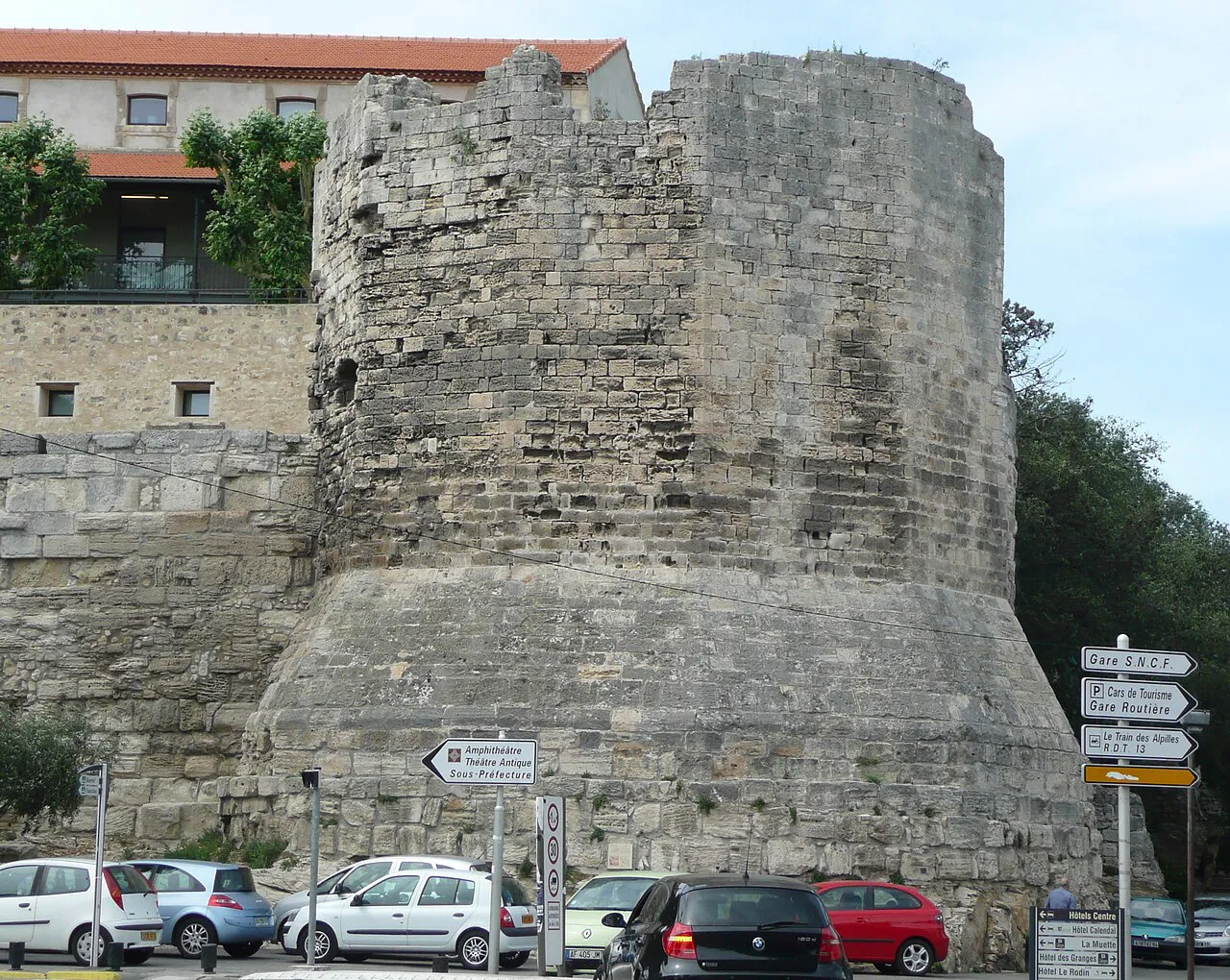 Remains of the round Tour des Mourgues on the old city walls of Arles above parked cars