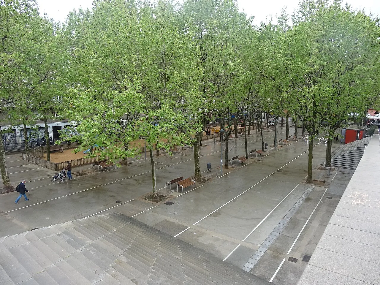 Paved square with rows of young trees in Parc de l'Espanya Industrial near Sants, Barcelona