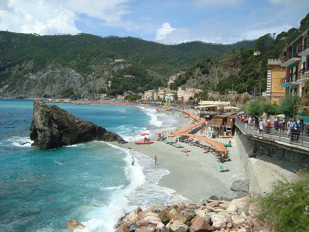 Monterosso al Mare beach with its large offshore rock, turquoise water and green hills behind