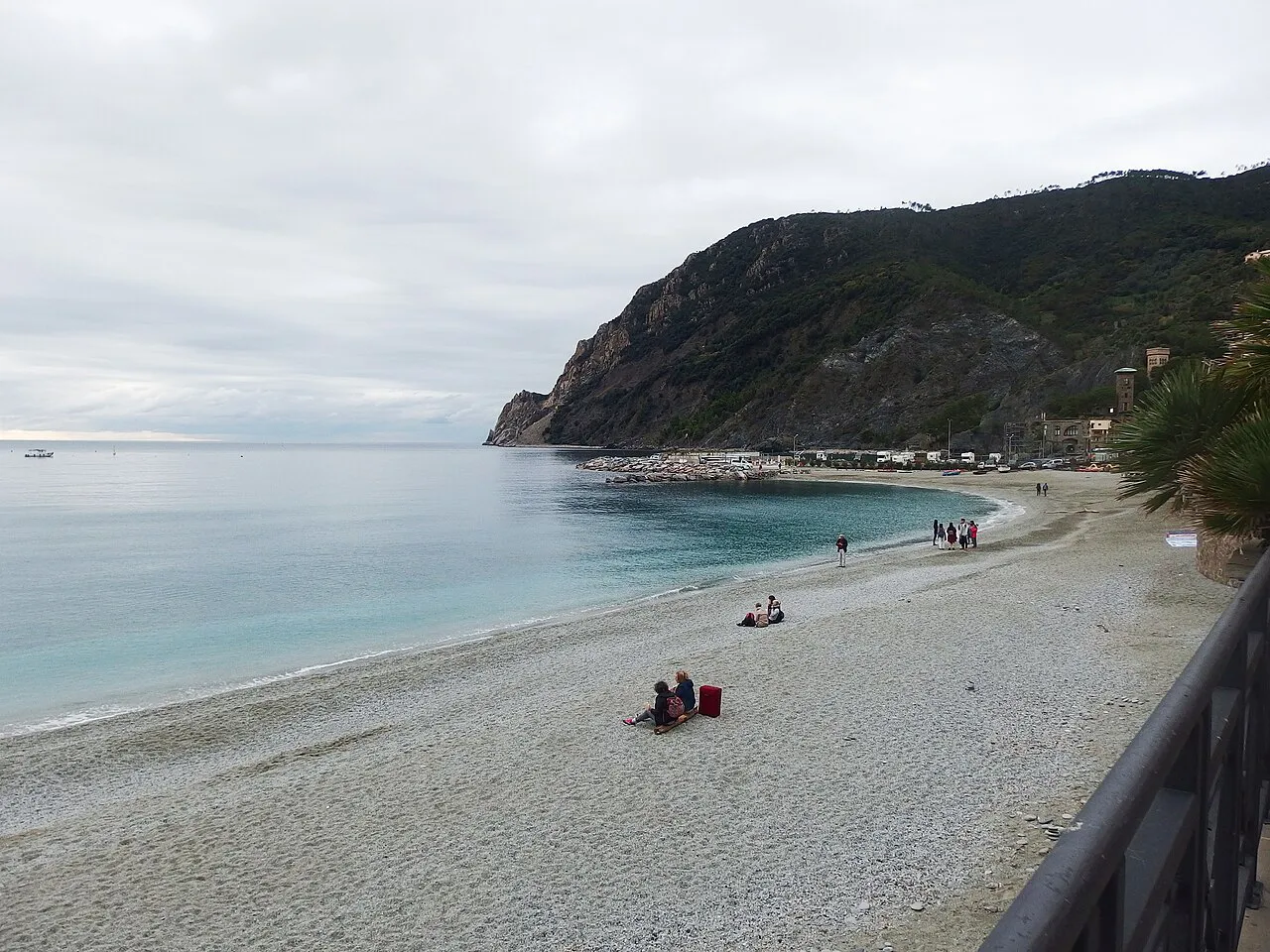 Quiet pebble beach at Monterosso al Mare curving towards a wooded headland