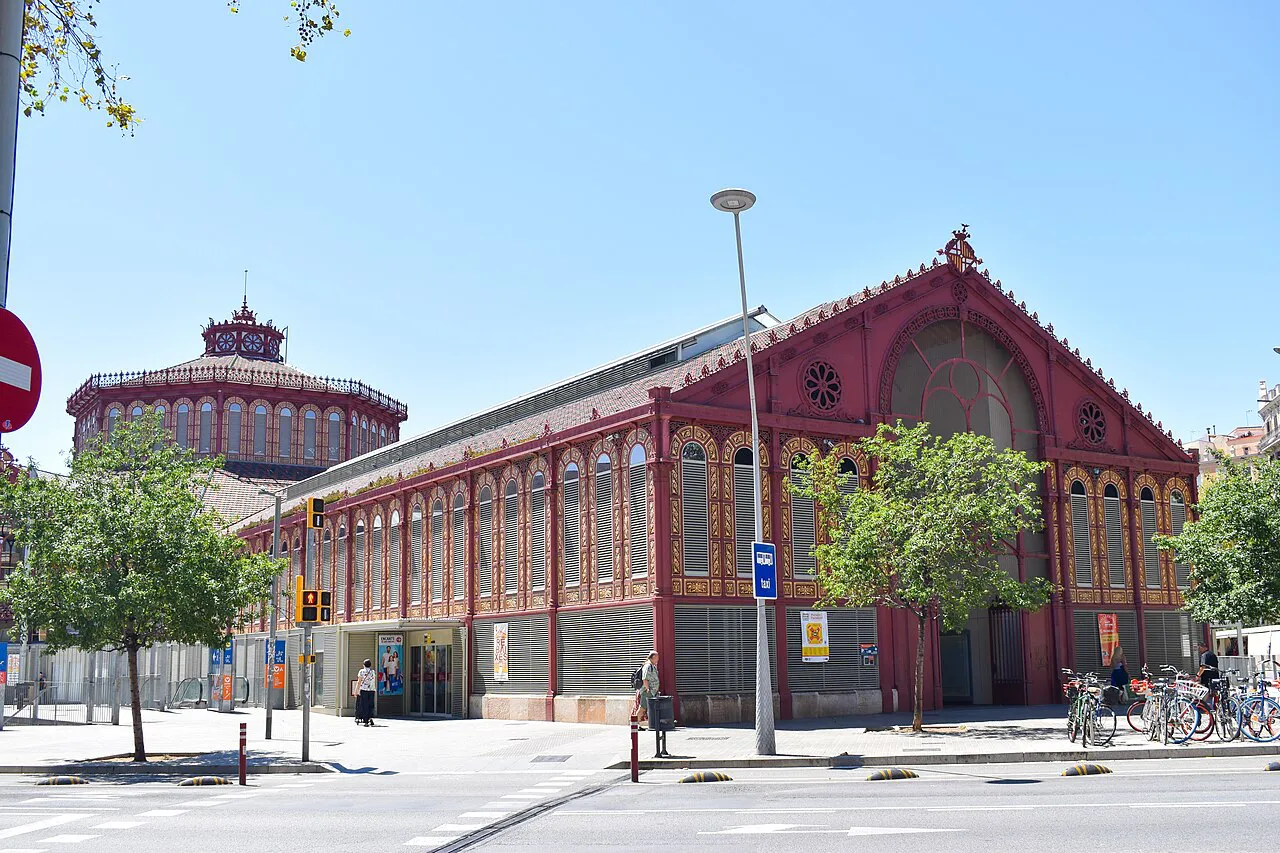 Red-brick and iron Mercat de Sant Antoni market hall on a sunny street in Barcelona's Eixample