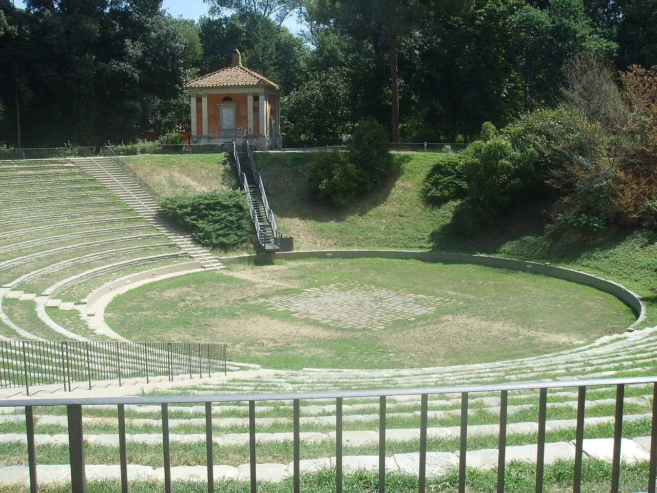 Grassy open-air amphitheatre among trees in the Parco delle Cascine, Florence