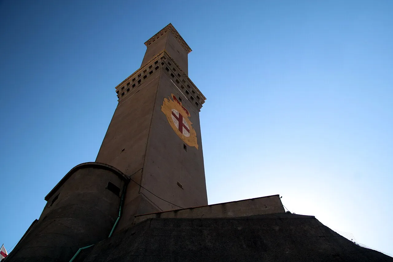 The Lanterna lighthouse tower of Genoa with the red cross of St George against a blue sky