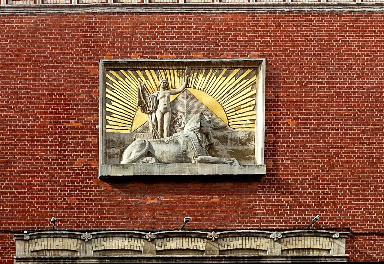Gilded sphinx relief set into a red-brick wall on Rue Thiers in Vieux-Lille