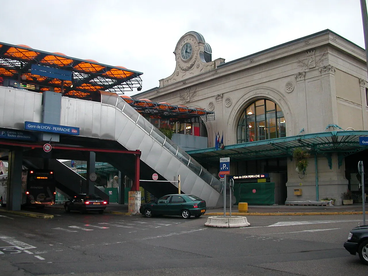 Stone facade and clock of Lyon-Perrache station beside the elevated walkways of the Perrache interchange