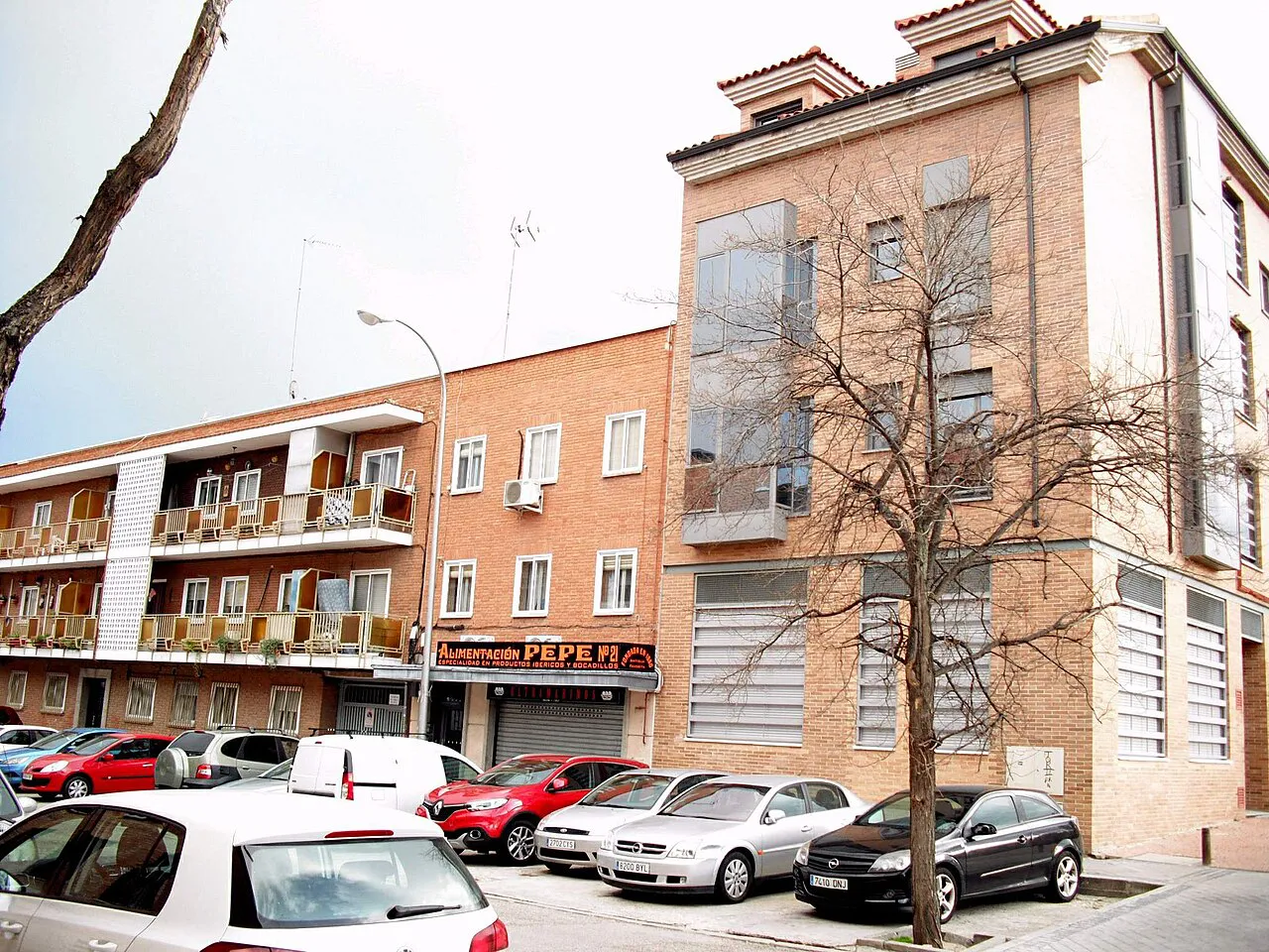 Brick apartment buildings and parked cars on a residential street in the Barajas district of Madrid