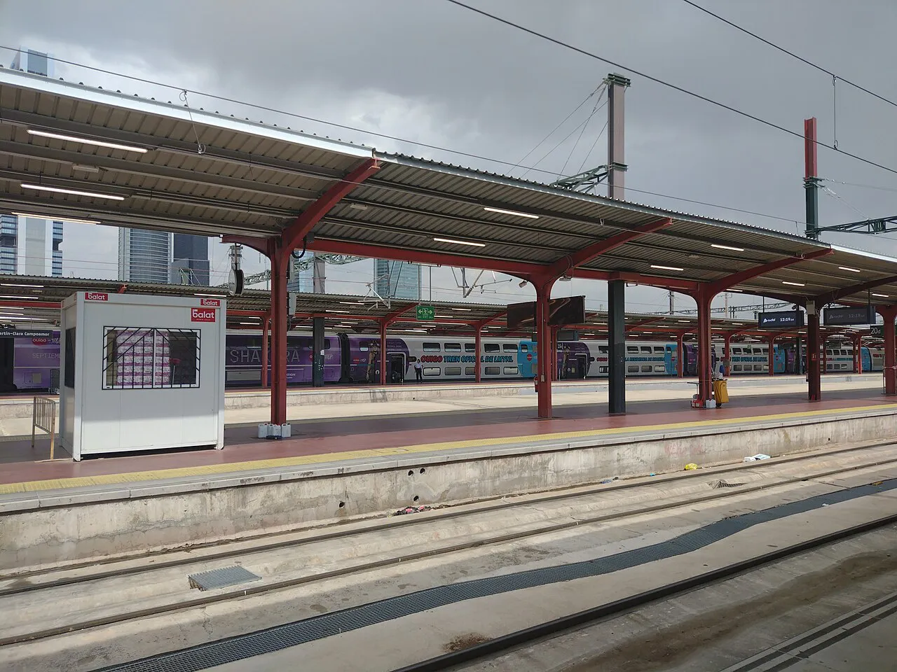 Canopied platforms and tracks at Madrid-Chamartín-Clara Campoamor station under a grey sky
