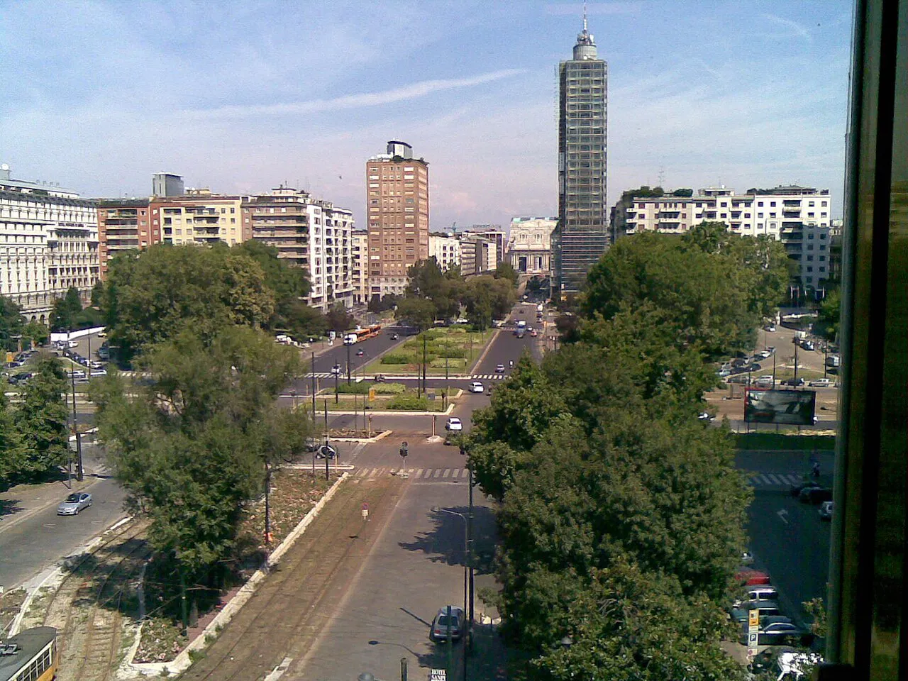 Elevated view over Piazza della Repubblica in Milan, with tree-lined avenues and a tall tower