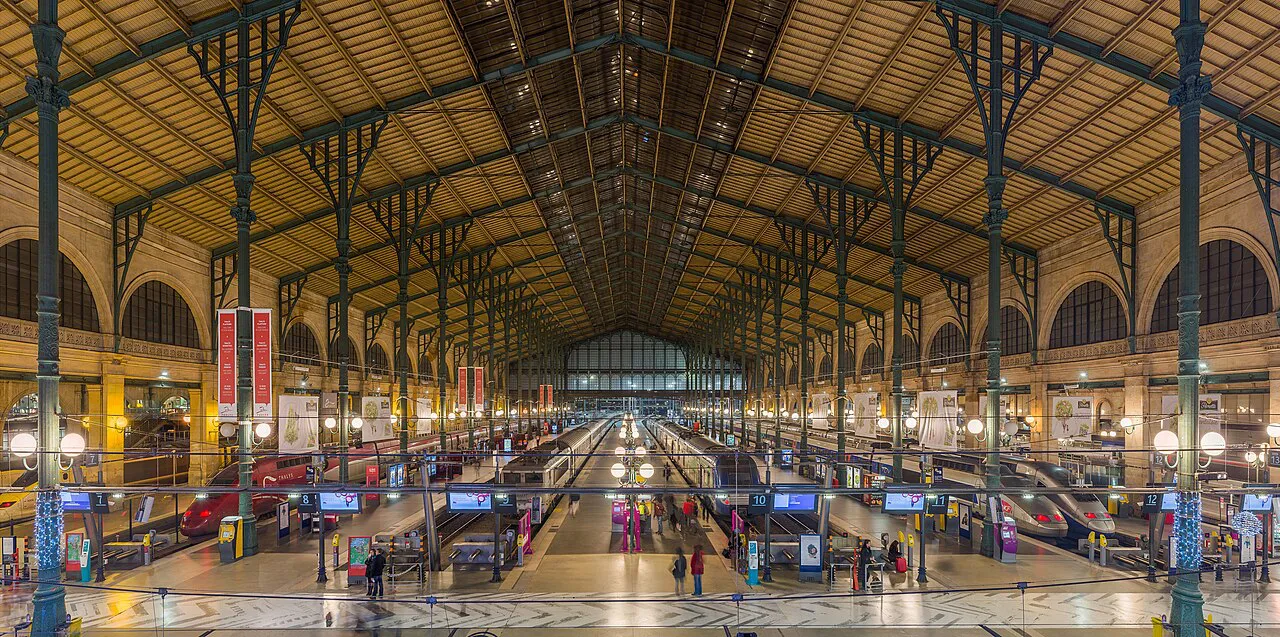 Platforms beneath the iron and glass train shed of Gare du Nord, Paris