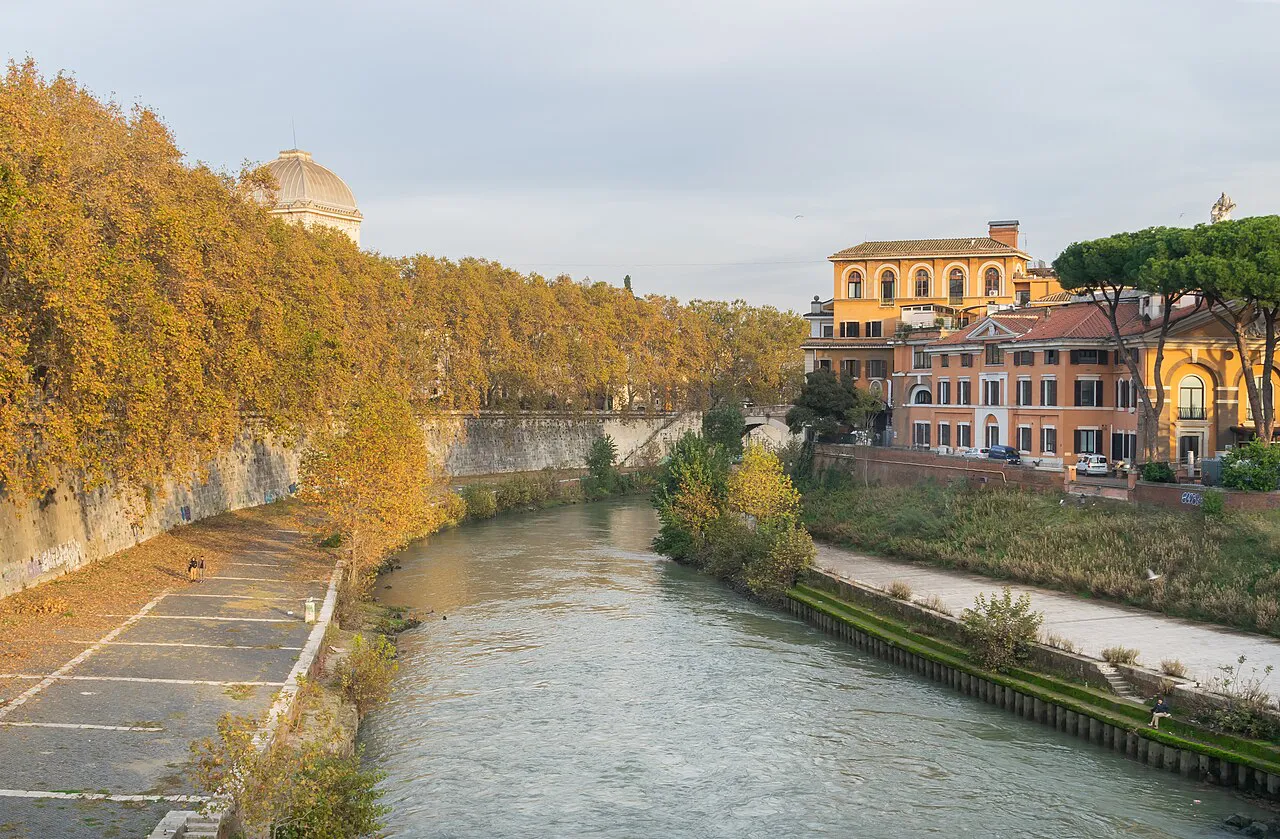 The Tiber at Lungotevere de' Cenci in Rome, with autumn trees along the embankment and ochre buildings