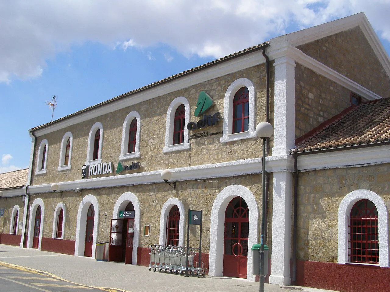 Stone-built Ronda railway station building with arched doorways and windows