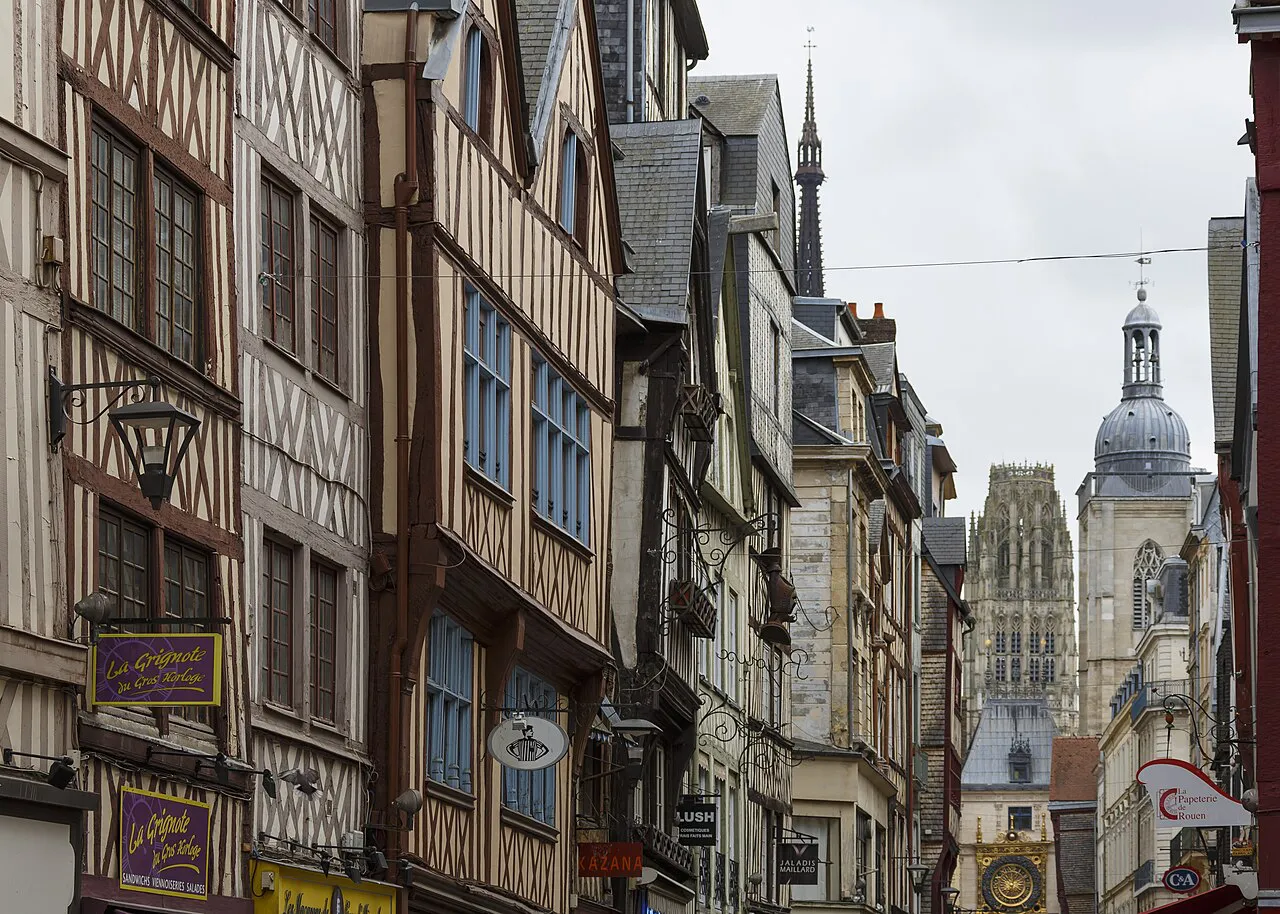 Narrow Rouen street of half-timbered houses leading toward the cathedral tower and Gros-Horloge belfry