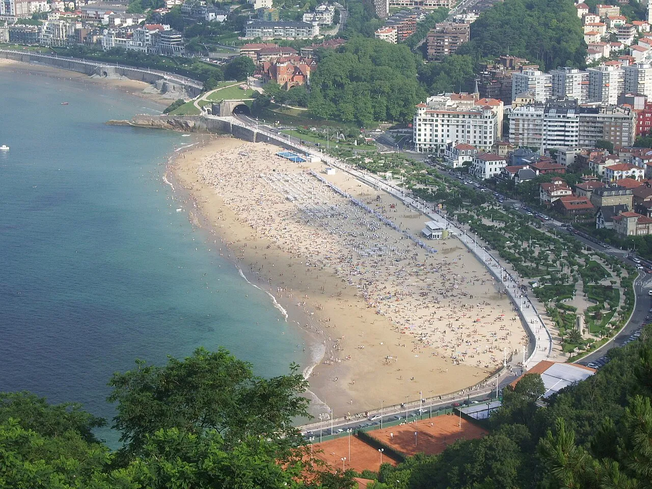 Aerial view of Ondarreta beach curving along the bay with the promenade and city behind, San Sebastián