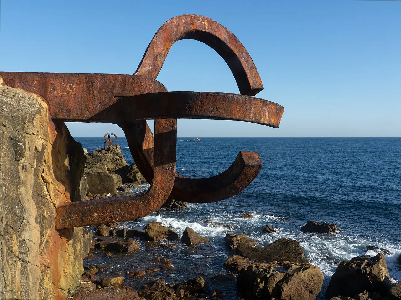 Rusted steel Peine del Viento sculpture by Eduardo Chillida anchored to rocks above the sea, San Sebastián