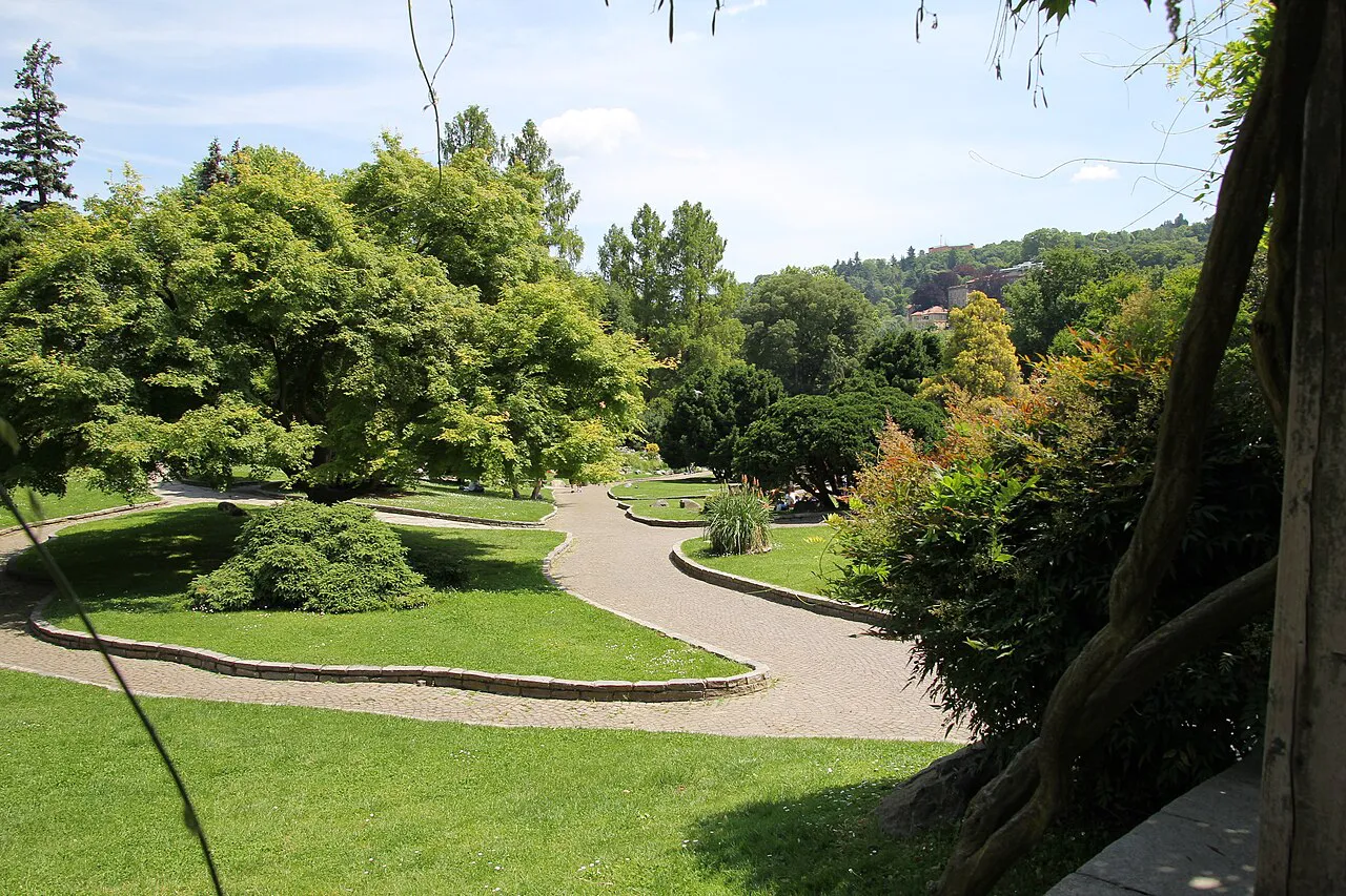 Winding paths, lawns and mature trees in Turin's Parco del Valentino on a sunny day