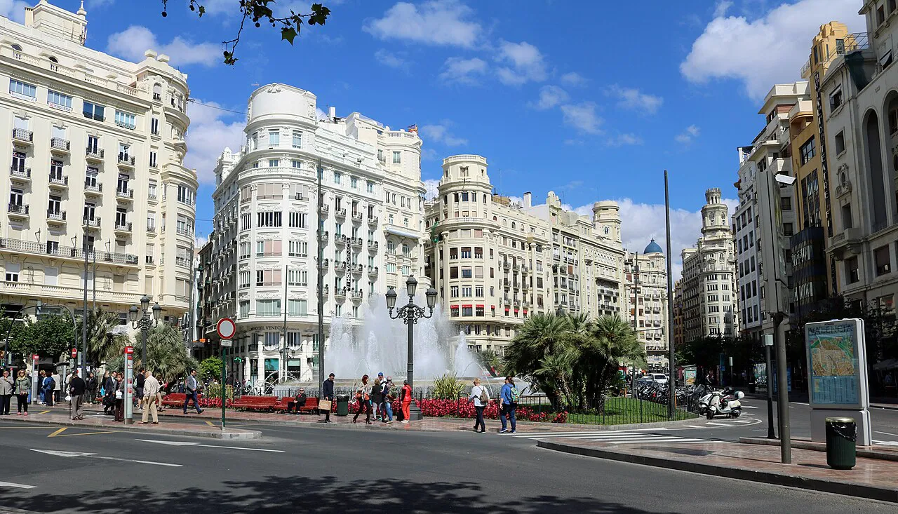 White early-20th-century buildings and a fountain on Plaza del Ayuntamiento in central Valencia
