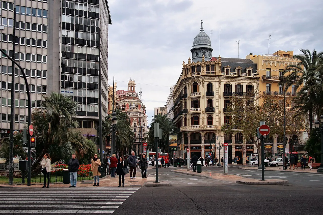 Street corner with palms and a domed period building off Plaza del Ayuntamiento in Valencia