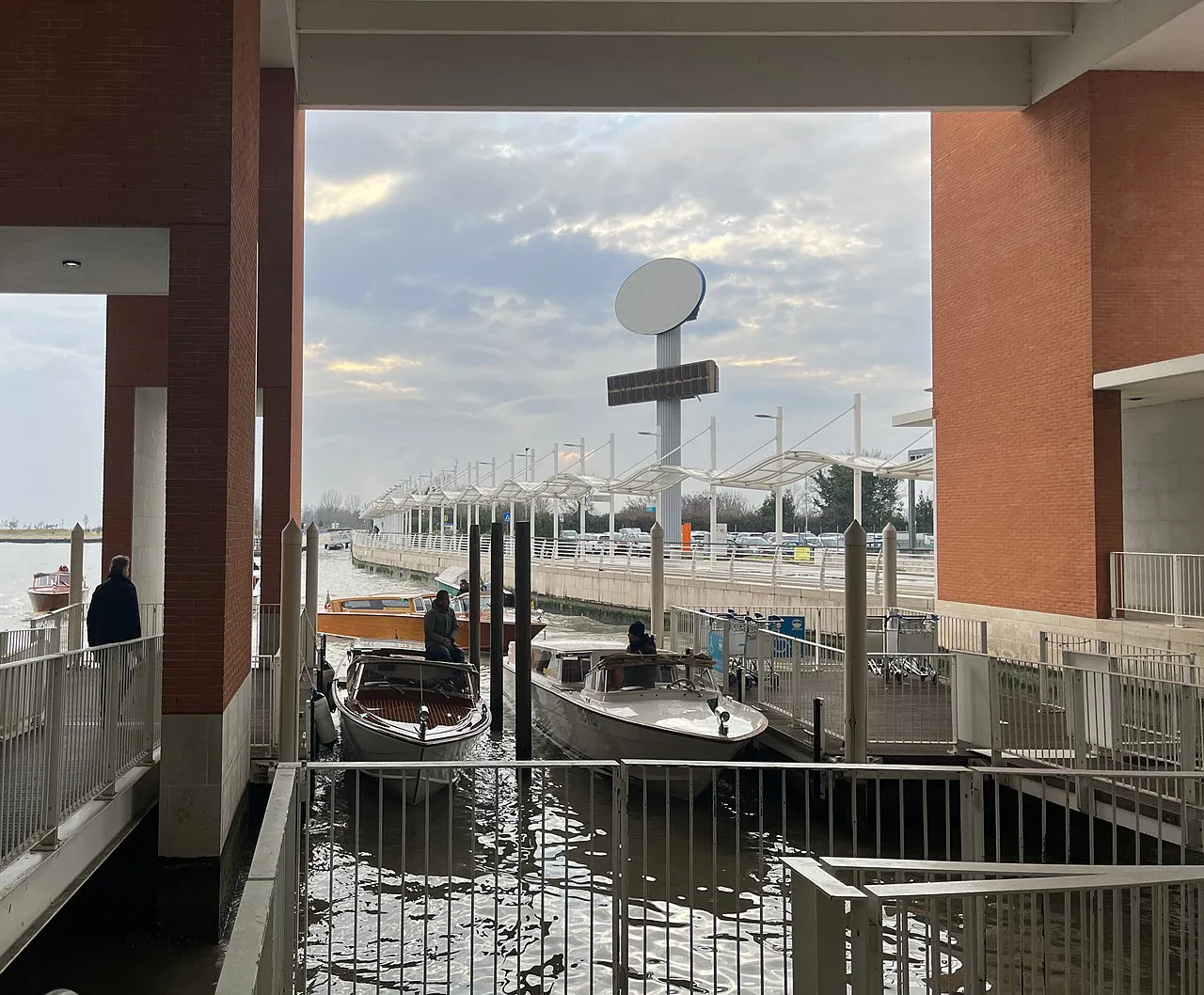 Covered water terminal with boats moored at the jetty at Venice Marco Polo Airport