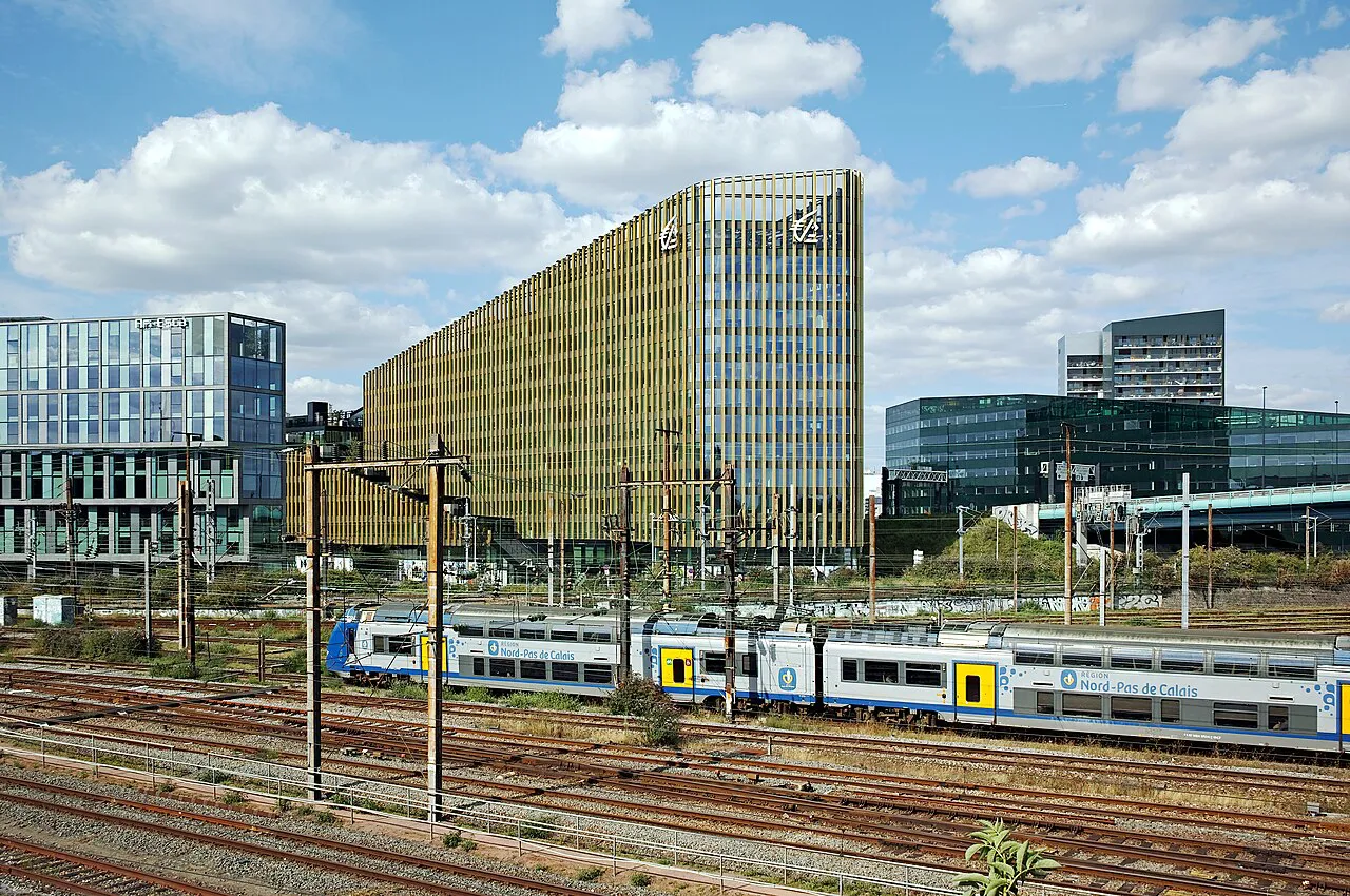 Regional train on the tracks approaching Lille-Flandres with Euralille office towers behind