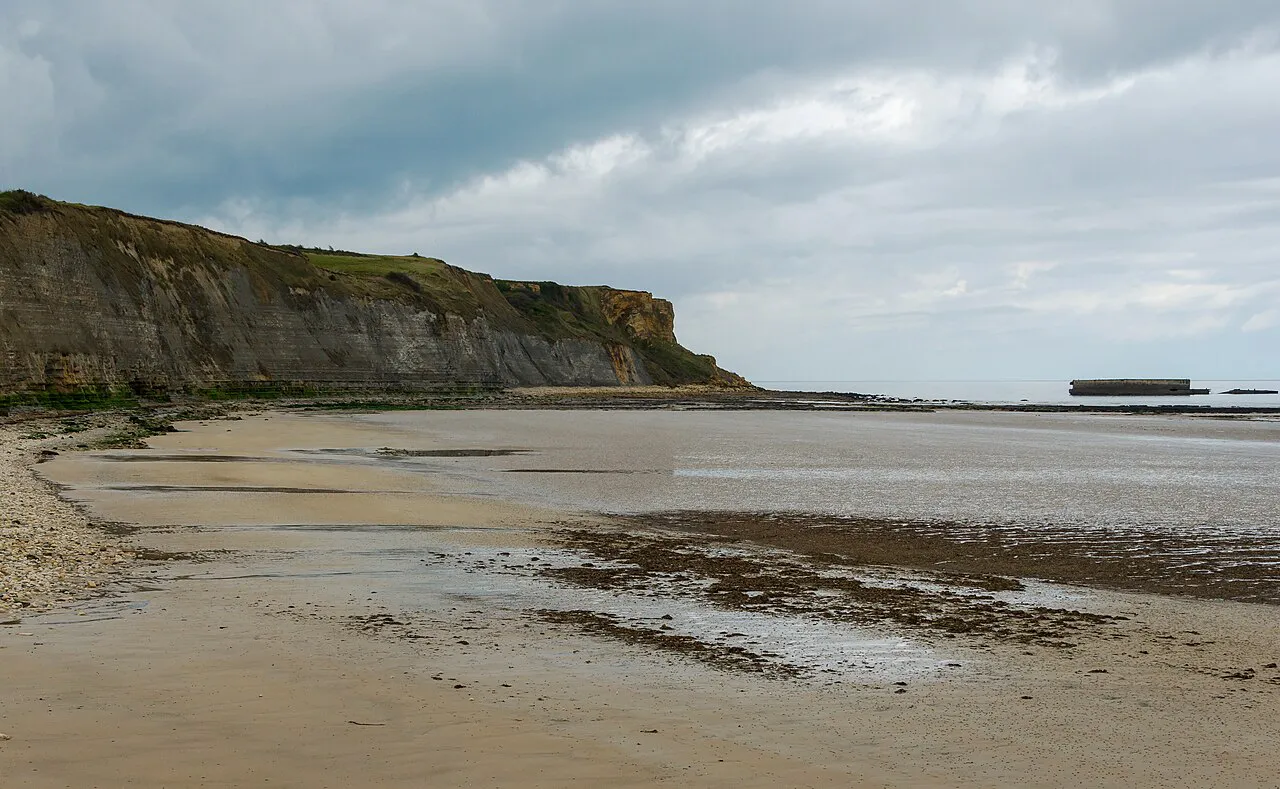 Gold Beach at Arromanches-les-Bains looking west toward the cliffs of Cap Manvieux at low tide