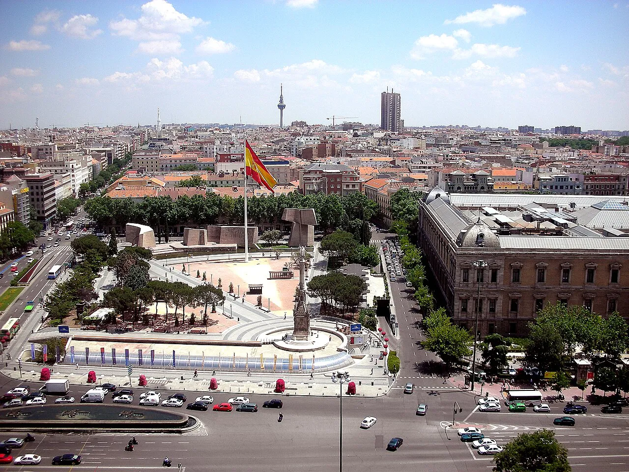 Elevated view over Plaza de Colón and the Jardines del Descubrimiento toward the Madrid skyline