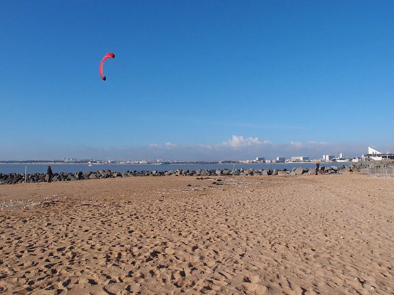 Wide sandy Plage des Minimes in La Rochelle with a kite surfer over the bay