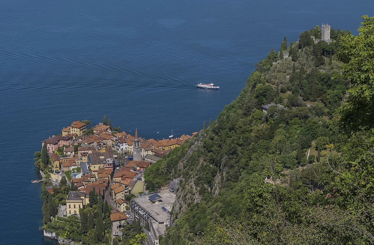 Varenna’s rooftops on a lakeside promontory below the wooded hill topped by Castello di Vezio