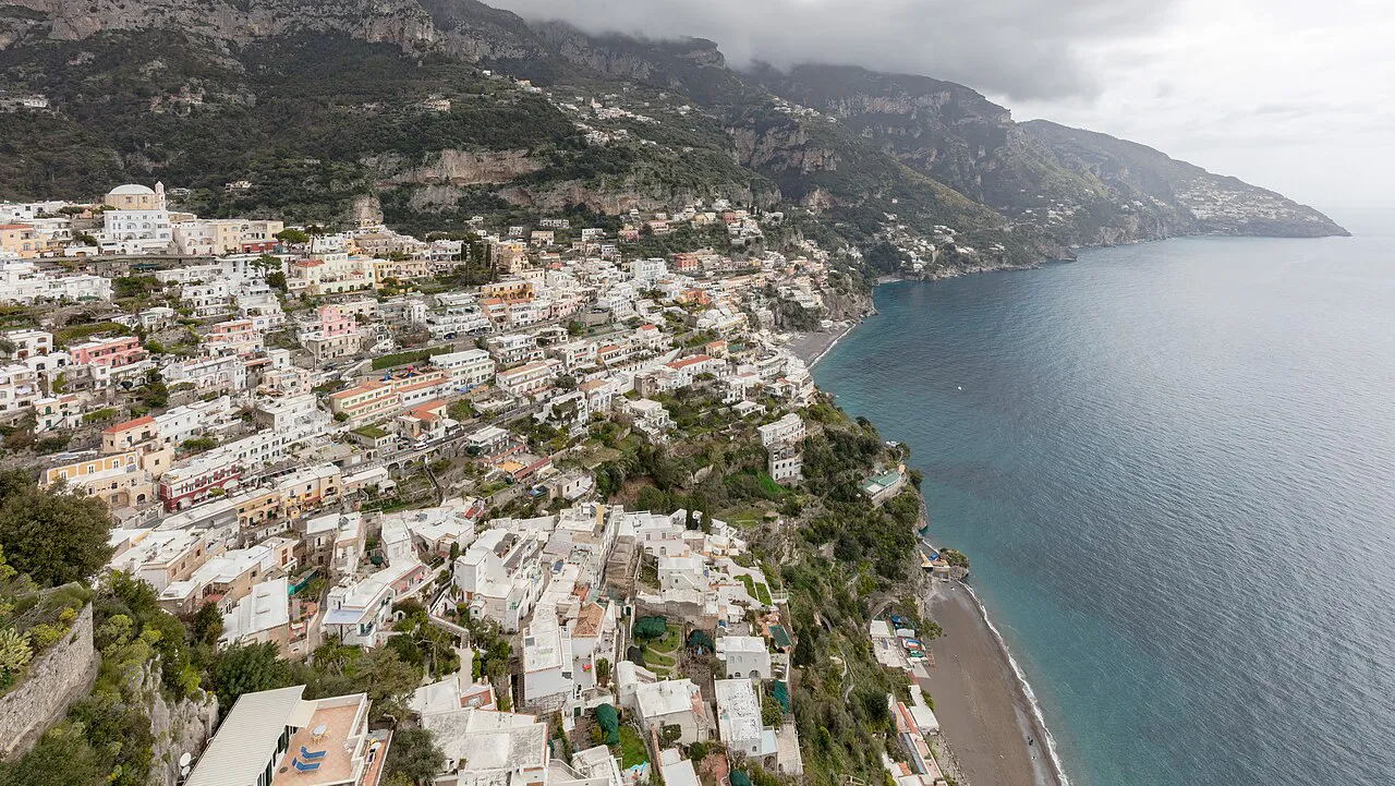 Aerial view of Positano's white and pastel houses spilling down to the sea along the Amalfi Coast