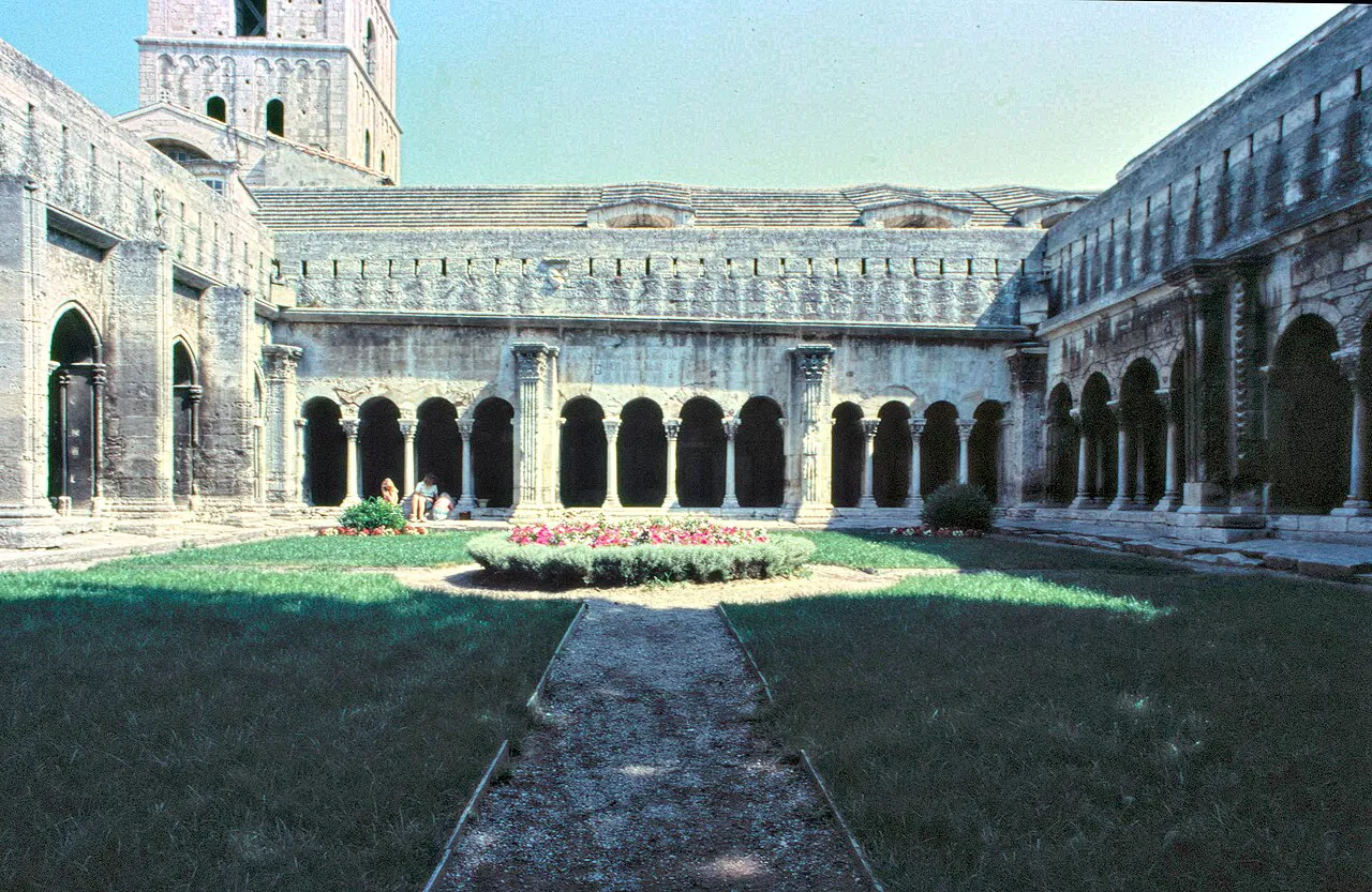 Arcaded Romanesque cloister of Saint-Trophime in Arles around a central lawn with flower beds