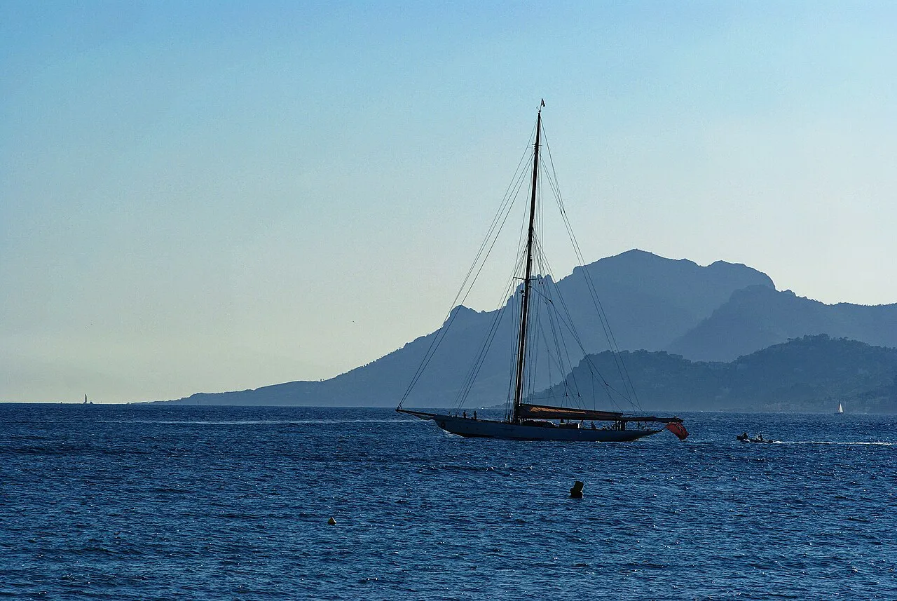 Classic sailing yacht in the Bay of Cannes with the Esterel mountains silhouetted behind