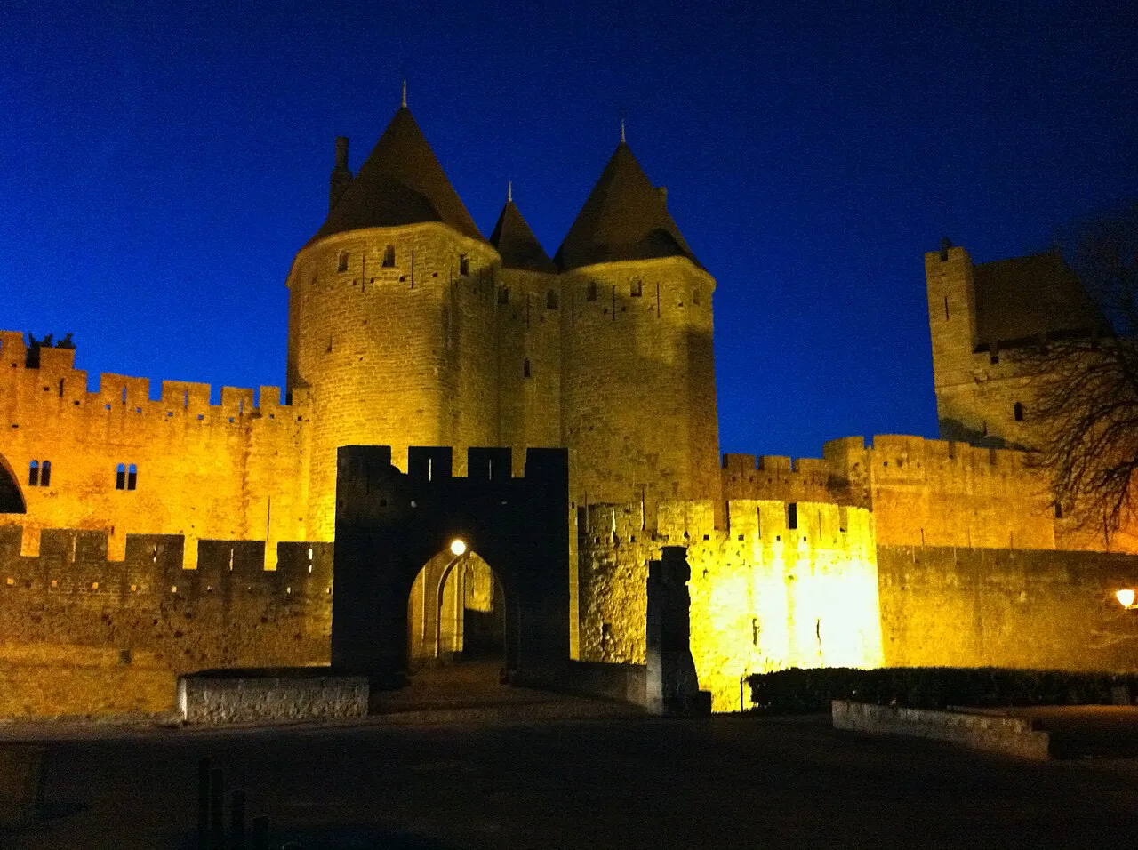 Floodlit twin towers of the Porte Narbonnaise gate into the Cité de Carcassonne at dusk