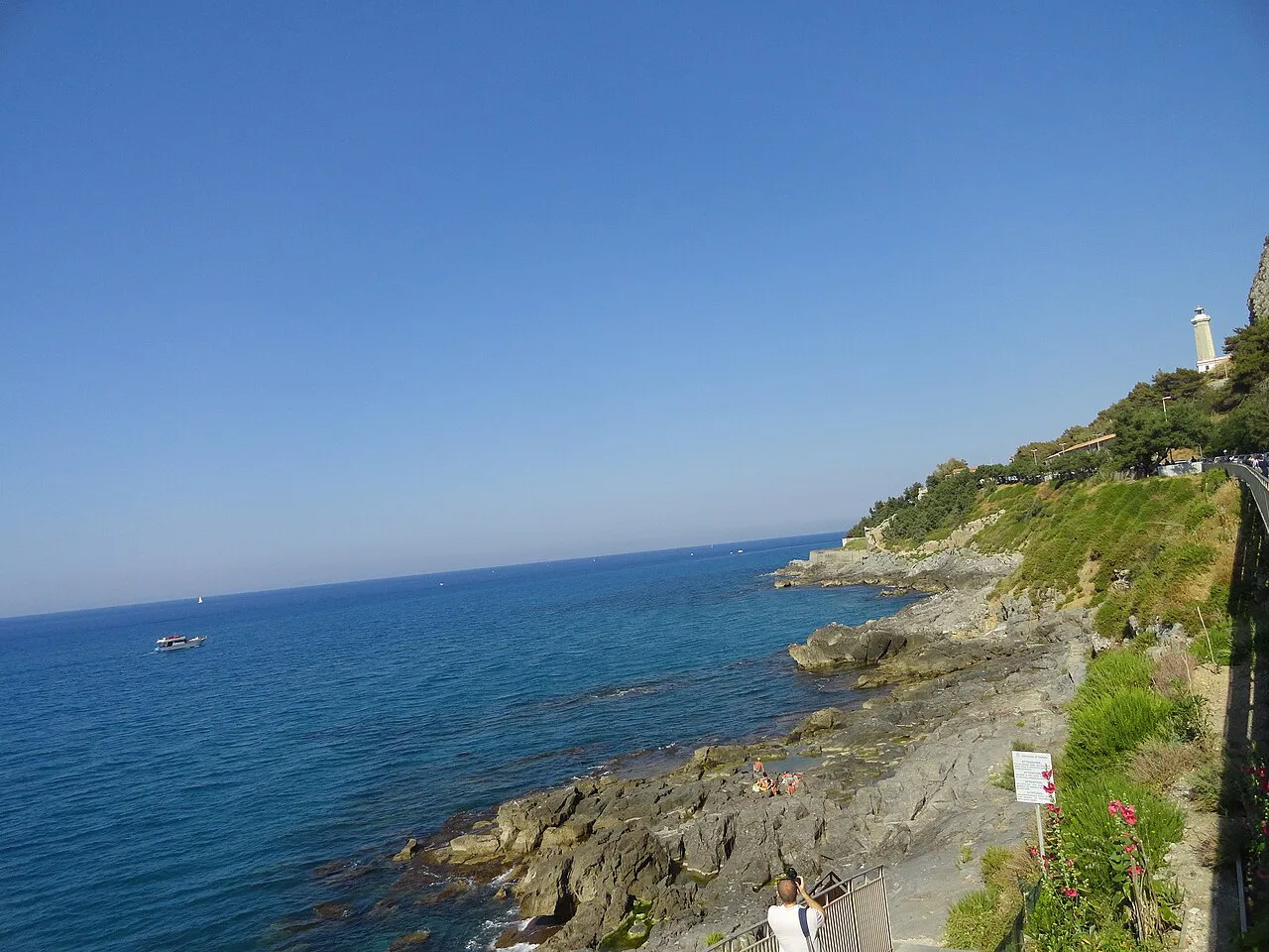 Rocky coastline and clear blue sea below the lighthouse headland at Cefalù