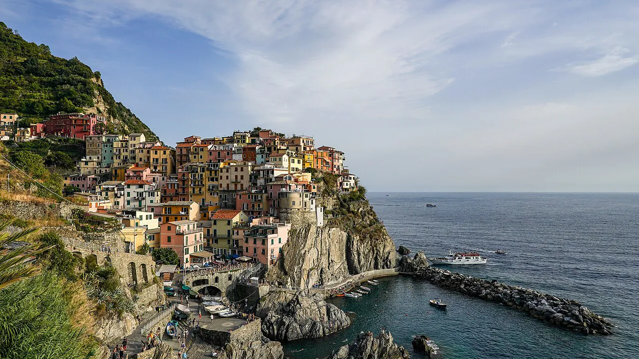 Colourful houses of Manarola stacked on a rocky headland above its small harbour in Cinque Terre