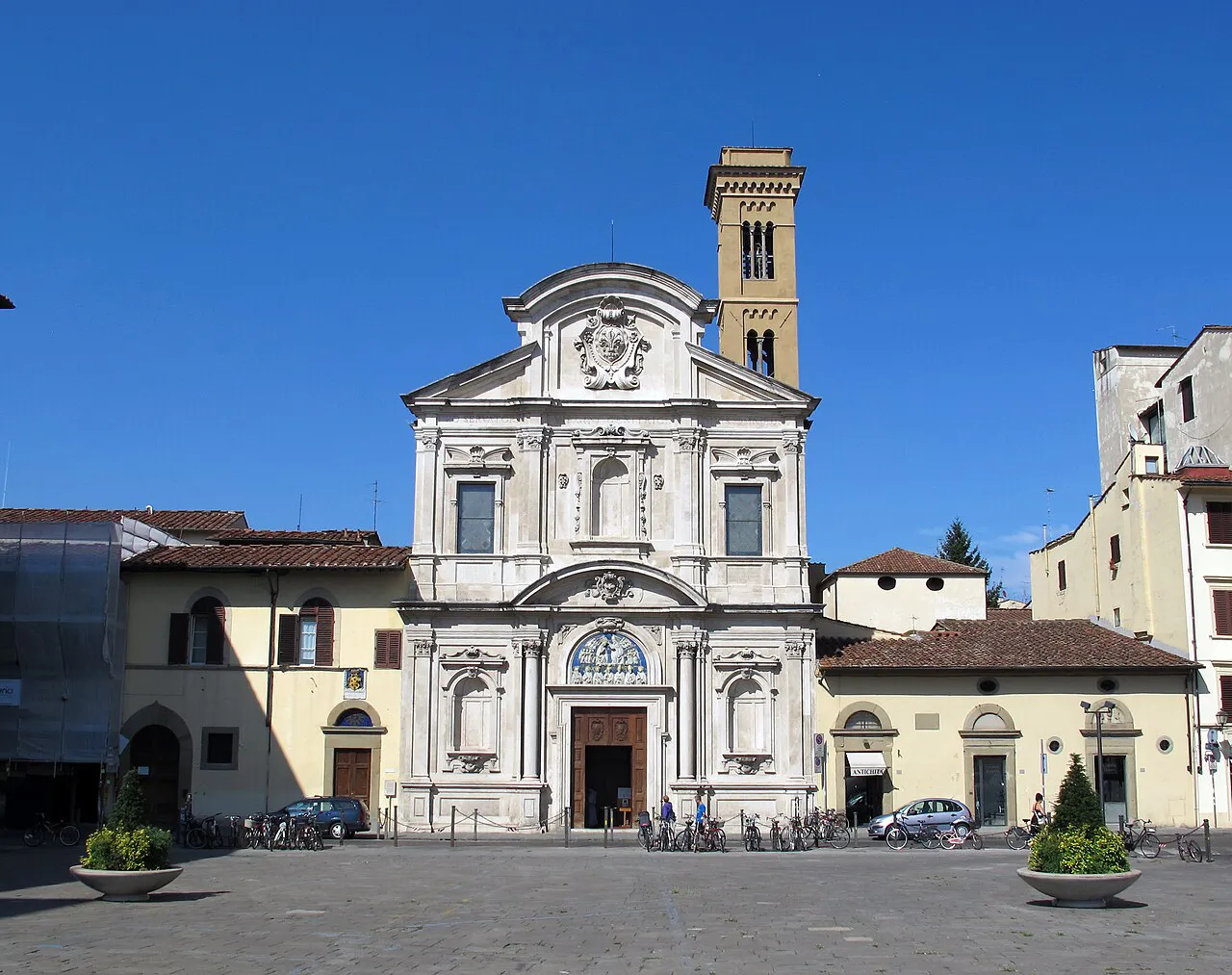 White baroque facade and bell tower of the Ognissanti church on Piazza Ognissanti, Florence