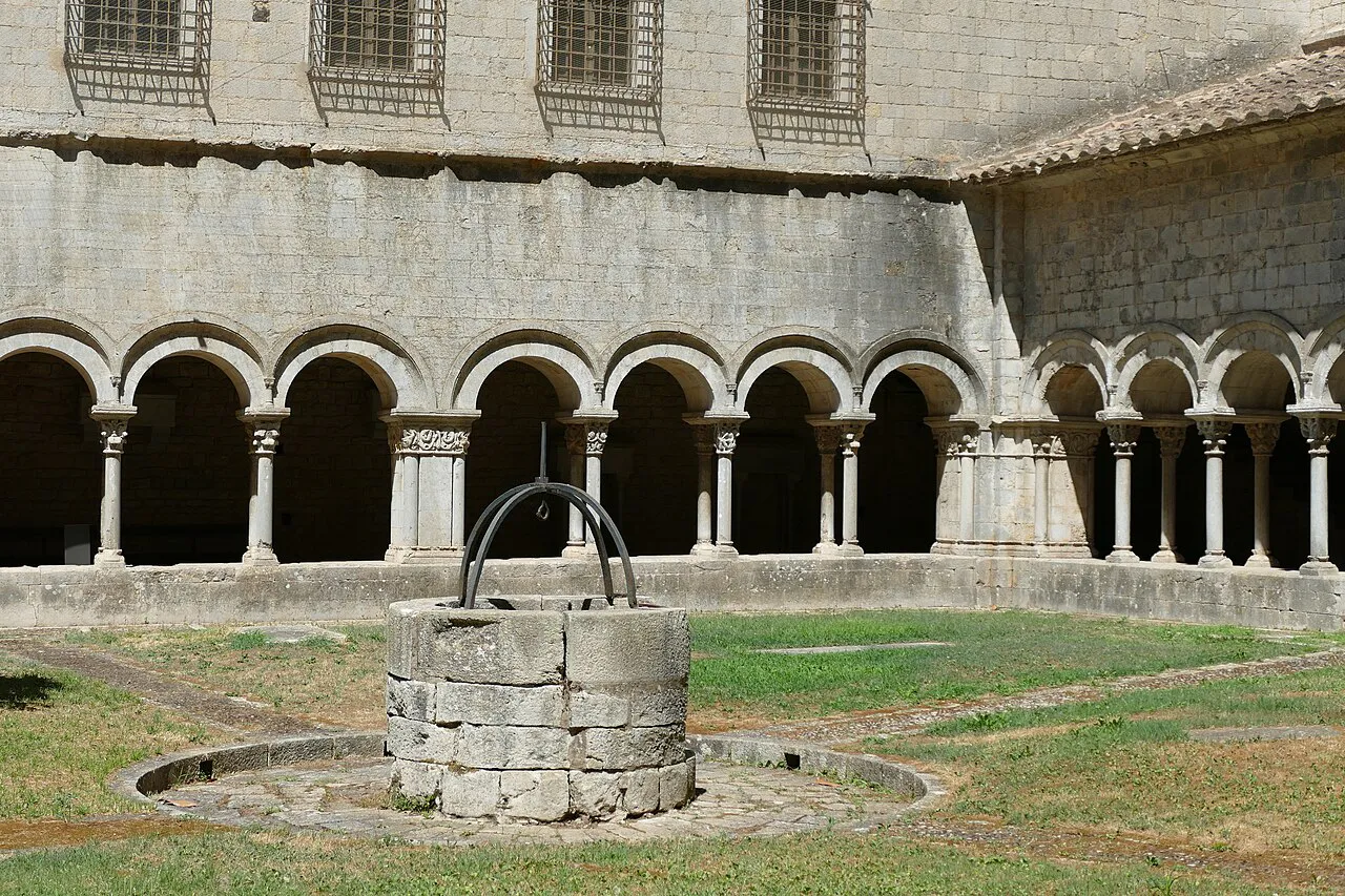 Romanesque arcades and an old stone well in the cloister of Girona Cathedral