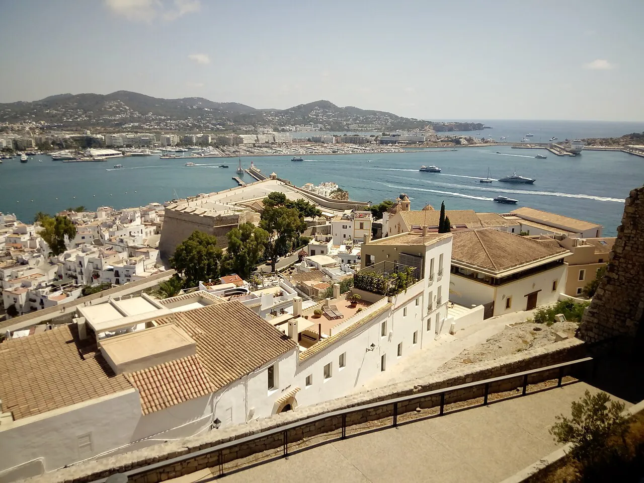 White houses of Ibiza Town's La Marina below Dalt Vila, with the harbour and hills beyond