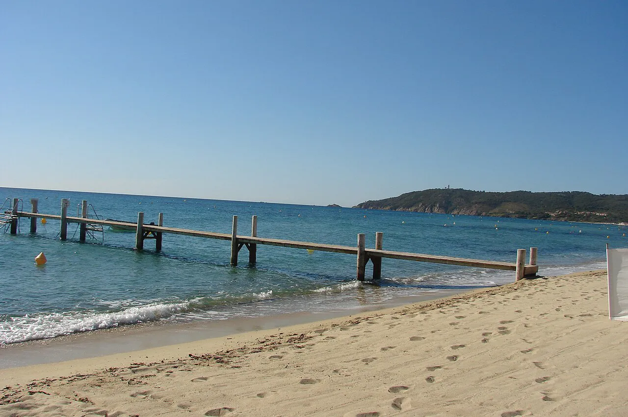 Wooden jetty reaching into calm sea off the sandy shore of Pampelonne beach, Ramatuelle