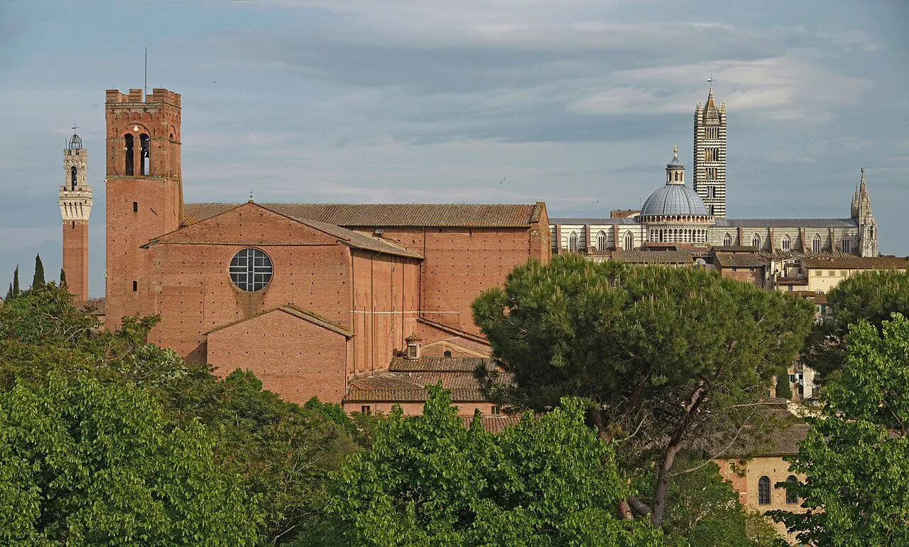The brick Basilica of San Domenico with Siena Cathedral's dome and bell tower and the Torre del Mangia behind