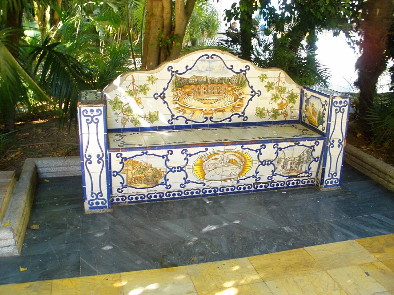 Hand-painted ceramic tiled bench among tropical plants in Marbella's Alameda Park