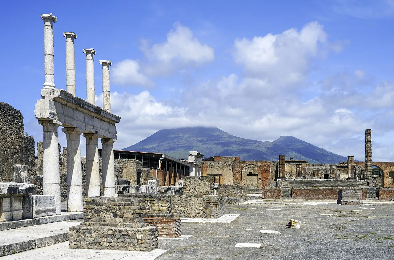 Columns of the Forum at Pompeii with Mount Vesuvius rising under a blue sky
