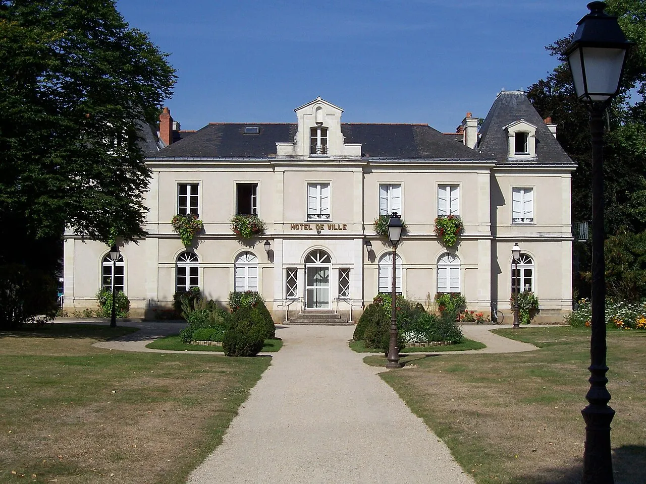 Stately town hall of La Chapelle-sur-Erdre behind a lawn and tree-lined path, north of Nantes