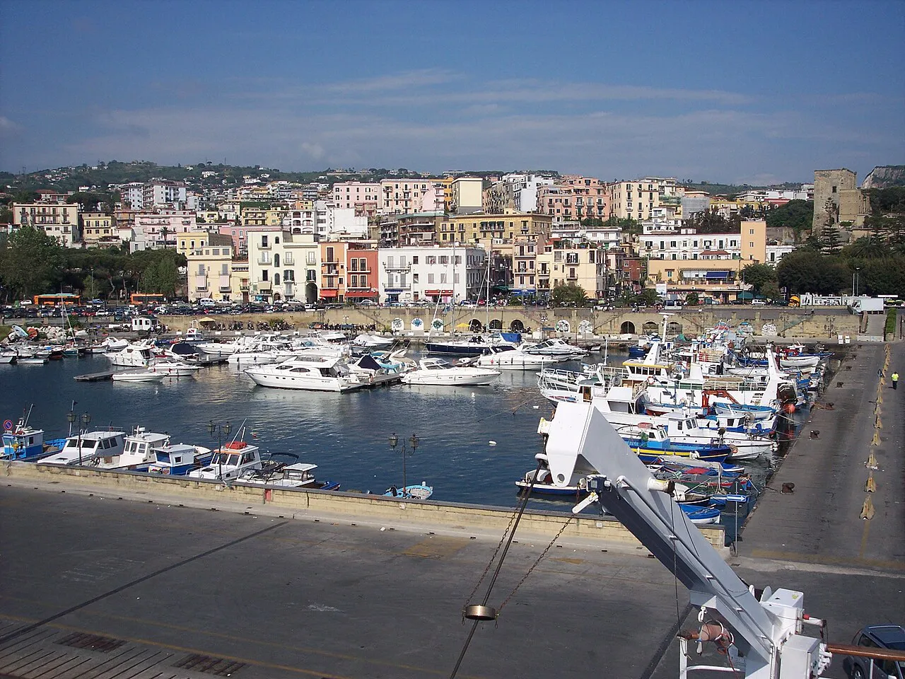 Boats moored in the harbour of Pozzuoli with the hillside town behind