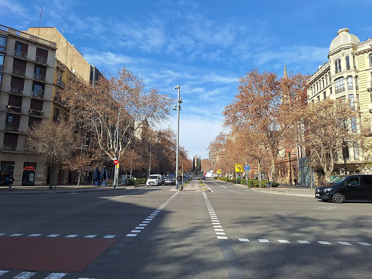 Wide crossing and tree-lined central walkway of Passeig de Sant Joan in Barcelona's Eixample