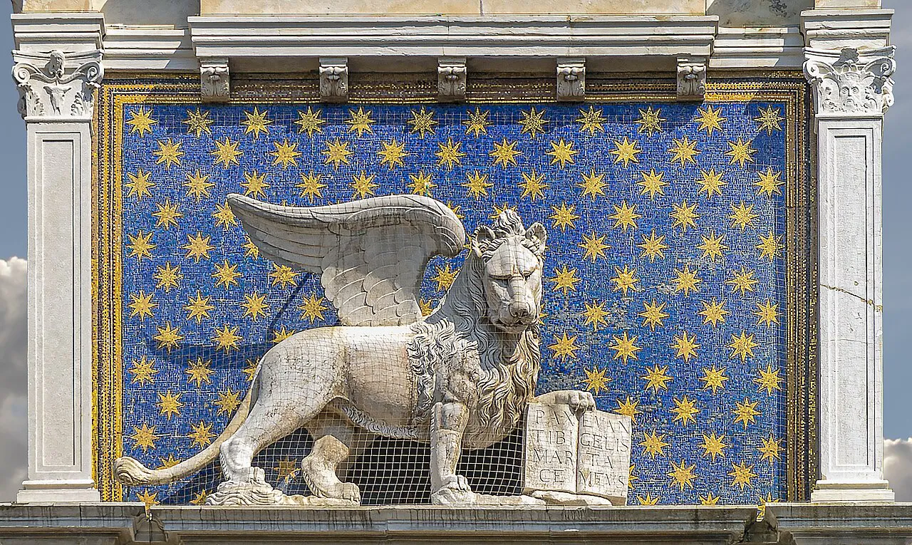 Gilded winged Lion of St Mark against a blue starry background on the Clock Tower, Piazza San Marco, Venice